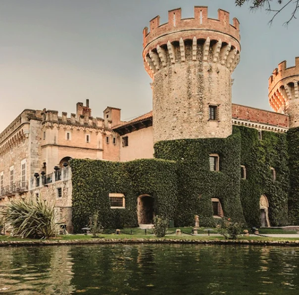 Vista general del Castell de Peralada, amb els jardins i un petit llac que envolta l’edifici històric.
