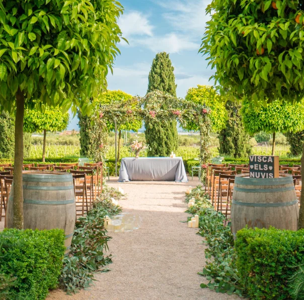 Cerimònia de casament a l’aire lliure a L’Orangerie de Clos Barenys, envoltada de vinyes, jardins i tarongers, en un entorn natural i elegant a Catalunya.