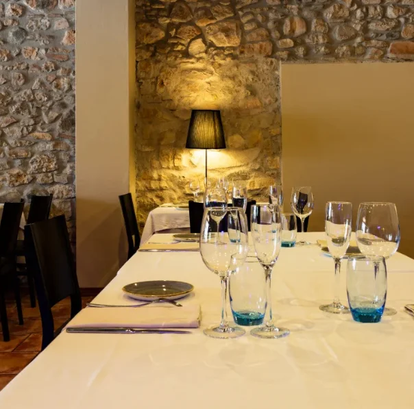 Interior d’Art Restaurant amb taules decorades amb copes i llums elegants, mostrant l’ambient acollidor i sofisticat per a banquets, celebracions i casaments a L’Espluga de Francolí