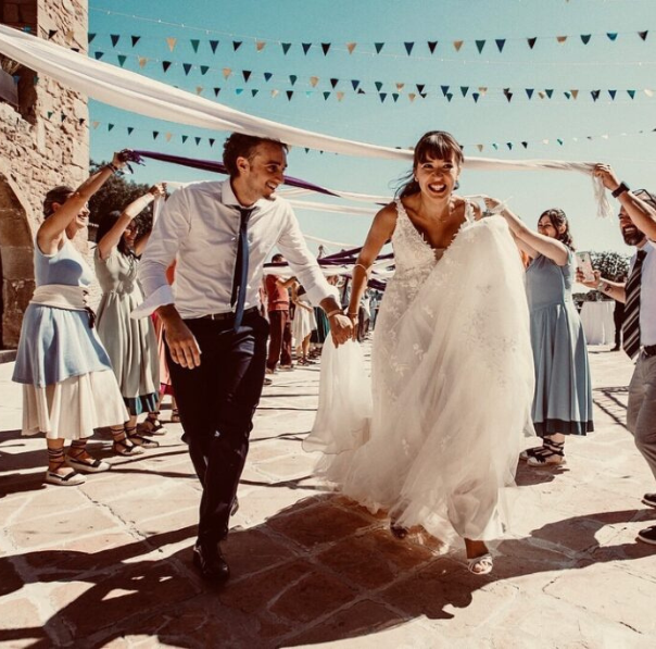 Pareja recién casada sonriendo y celebrando su enlace en una ceremonia romántica al aire libre